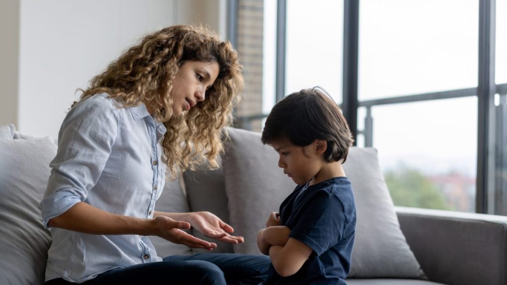 Latin American boy at home having a tantrum at home and mother trying to talk to him - lifestyle concepts