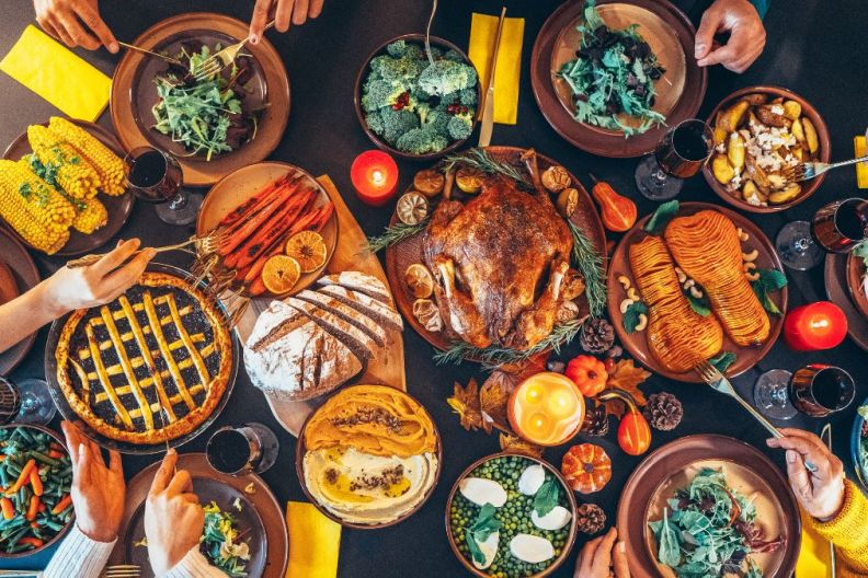 Festive table with roasted turkey on it, a Thanksgiving dinner recipe you can easily make using a slow cooker.