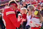 Patrick Mahomes #15 of the Kansas City Chiefs fist bumps his son, Bronze, while his wife and daughter, Brittany and Sterling, watch prior to a game against the Denver Broncos at GEHA Field at Arrowhead Stadium on November 10, 2024 in Kansas City, Missouri.