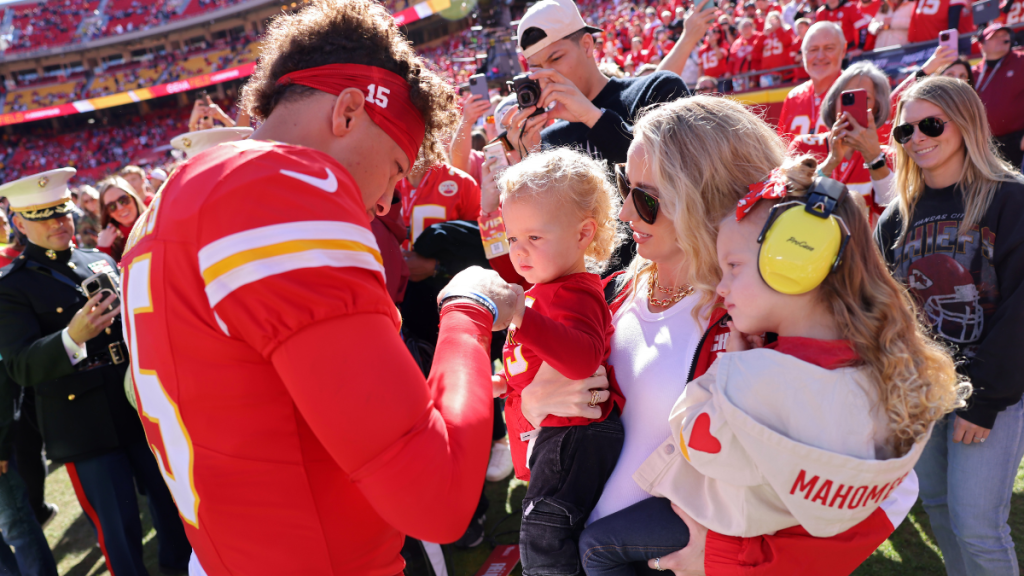 Patrick Mahomes #15 of the Kansas City Chiefs fist bumps his son, Bronze, while his wife and daughter, Brittany and Sterling, watch prior to a game against the Denver Broncos at GEHA Field at Arrowhead Stadium on November 10, 2024 in Kansas City, Missouri.