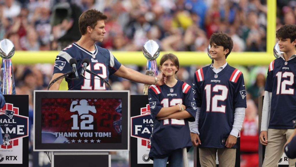 Former New England Patriots quarterback Tom Brady grabs his daughter's, Vivian, cheek while his sons, Benjamin and Jack, look on during a halftime ceremony during a game between the New England Patriots and the Philadelphia Eagles at Gillette Stadium on September 10, 2023 in Foxborough, Massachusetts.