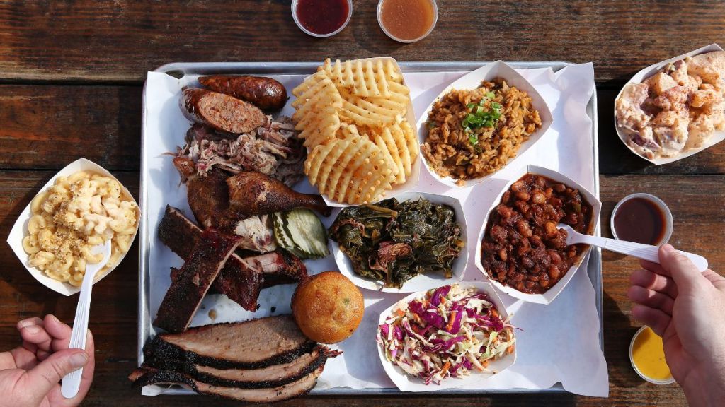 A full BBQ snack platter with Mac & cheese, cole slaw, beans, greens, potato salad and fries, which will make for a great budget-friendly Christmas gift for your host.