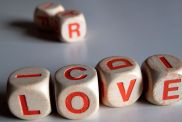 White and orange scrabble dice spelling the word "love."