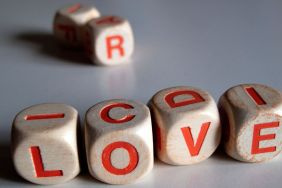 White and orange scrabble dice spelling the word "love."