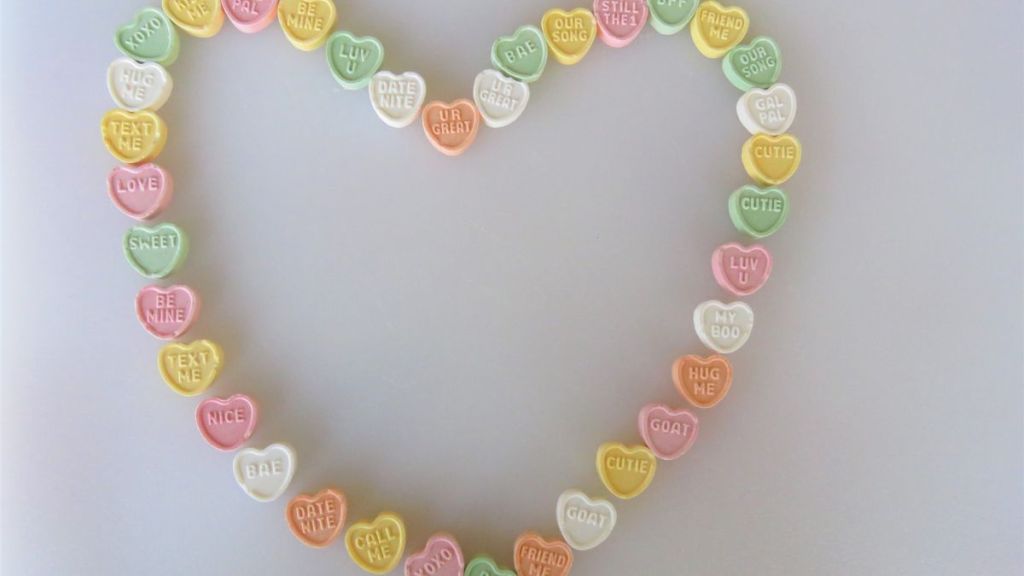 Conversation heart candies in a heart shape, perfect for Valentine's Day.